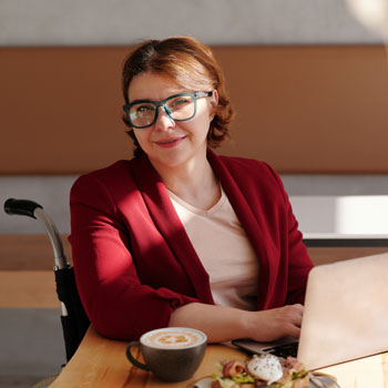 Femme en fauteuil roulant devant un ordinateur portable