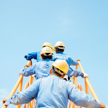 Hommes portant des casque de chantier et montant sur une passerelle