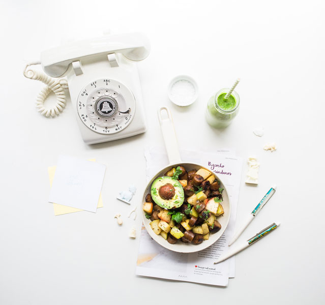 Vieux téléphone avec assiette repas équilibrée et boisson bio de couleur verte, le tout sur fond blanc