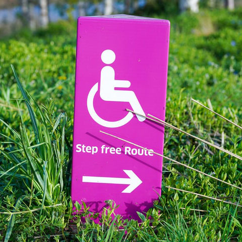 Panneau violet indiquant le chemin pour les fauteuils roulants